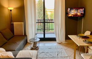 GaglianicoにあるGius' Apartment elegante vicino Ospedale Biellaのソファがありバルコニーが見えるリビングルーム +4枚の写真