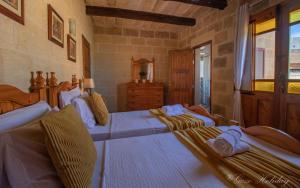 ein Schlafzimmer mit zwei Betten, auf denen die Leute liegen in der Unterkunft Tan-Nanna Holiday Home in Xagħra