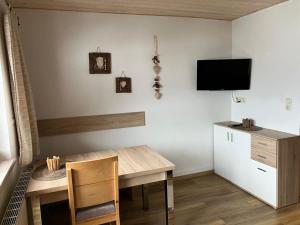 ein Esszimmer mit einem Tisch und einem TV an der Wand in der Unterkunft Ferienwohnung Erika Masuck in Grän