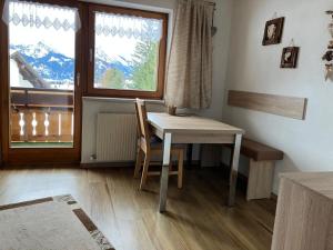 a table and chair in a room with a window at Ferienwohnung Erika Masuck in Grän