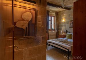 a bedroom with a bed in a stone wall at Tan-Nanna Holiday Home in Xagħra