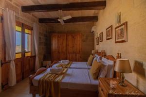 a bedroom with a bed and a table with a lamp at Tan-Nanna Holiday Home in Xagħra
