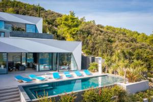a house with a swimming pool and blue chairs at Luxury Villa Korcula Diamond in Žrnovo