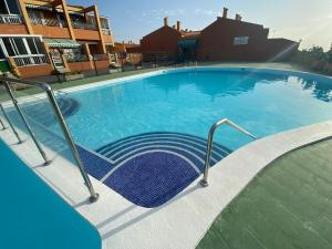 a large swimming pool with a chair in it at Simon beach house Los Cristianos in Los Cristianos