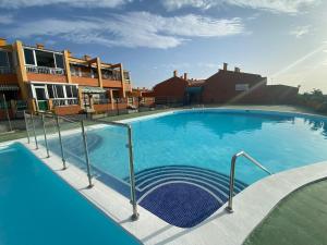 a large swimming pool with blue water at Simon beach house Los Cristianos in Los Cristianos