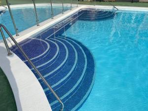 a swimming pool with blue water and stairs in it at Simon beach house Los Cristianos in Los Cristianos