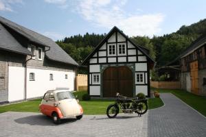 ein kleines Auto und ein Fahrrad, das vor einem Haus geparkt ist in der Unterkunft Traumferienhaus Sauerland in Schmallenberg