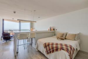 a bedroom with a bed and a desk and a kitchen at Luxury Suite with Seaview in Ostend