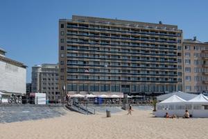 a large building on the beach with people on the sand at Luxury Suite with Seaview in Ostend