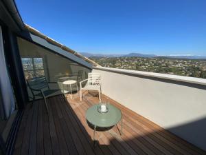 einen Balkon mit einem Tisch und Stühlen auf einem Gebäude in der Unterkunft Mougins Collection - Magnifique maison au Cœur du Vieux Village de Mougins, vue sur les Alpes du Sud in Mougins