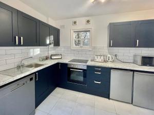uma cozinha com armários azuis e um lavatório em Park View em York