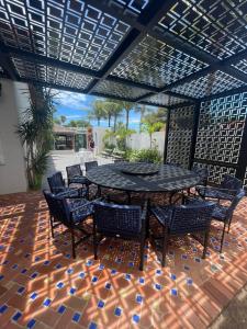 um pátio com uma mesa e cadeiras num piso de azulejo em BIG HOUSE SAQUA em Saquarema