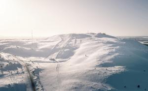 una montaña cubierta de nieve con una carretera en la parte superior en Economy Aarakka en Levi