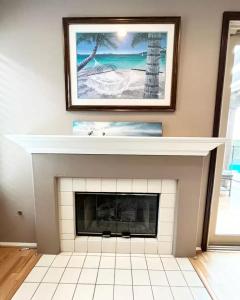 a living room with a fireplace with a picture above it at Casa Oasis/Pool & Jacuzzi/4 Bedroom/ Wi-Fi in Camarillo