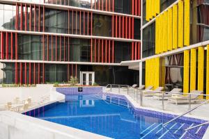 a swimming pool in front of a building at ibis Doha in Doha