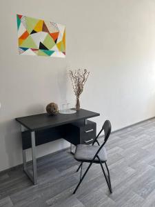 una scrivania nera e una sedia in una stanza di ГОТЕЛЬ RIDMAS a Bila Cerkva