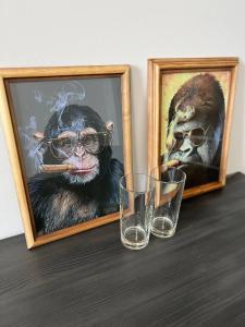 two glasses and a picture of a monkey smoking a cigar at ГОТЕЛЬ RIDMAS in Bila Tserkva