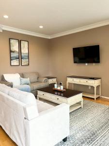a living room with white furniture and a flat screen tv at Casa Oasis/Pool & Jacuzzi/4 Bedroom/ Wi-Fi in Camarillo