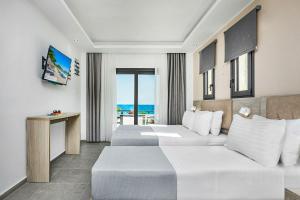 une chambre d'hôtel avec deux lits et un canapé dans l'établissement NewStory Luxury Suites Possidi, à Possidi