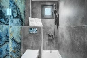 a bathroom with a sink and a toilet and a window at NewStory Luxury Suites Possidi in Possidi