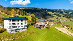 an aerial view of a building on a green hill at Eberharthof in Saalbach-Hinterglemm