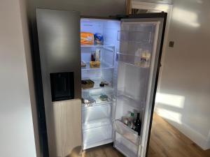 un réfrigérateur ouvert avec porte ouverte et étagères dans l'établissement Luxury 2 bed Apartment in Stoke-on-Trent, à Stoke-on-Trent