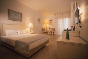 a hotel room with a bed and a table with chairs at Grand Hotel Madaba in Madaba