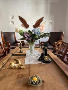 un vase de fleurs sur une table avec des oiseaux dans l'établissement Hotel Archangelus, à Mompós
