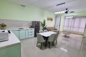 マラッカにあるBali Residence Melaka d'AwAn Homestayのテーブルと椅子のあるキッチンとダイニングルーム