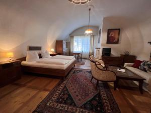 una camera da letto con un letto e un soggiorno di Hotel Gasthof Kohlmayr a Gmünd in Kärnten