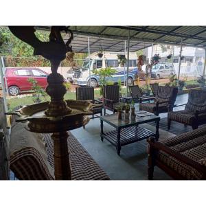 un patio con mesa, sillas, mesa y sillas en Nature Villa Kochi en Alwaye