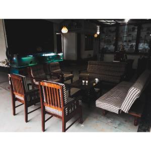 um grupo de cadeiras e uma mesa num quarto em Nature Villa Kochi em Alwaye