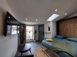 a bedroom with a bed and a table and a window at Les studios de Théophile - Calme absolu - Wifi - Centre historique in Arles