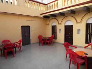 a room with red chairs and tables in a building at Foreigners Inn in Varanasi