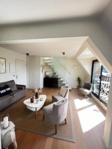 uma sala de estar com um sofá e uma mesa em Deauville Harmonie - Tout à pied, Balcon & Modernité em Deauville