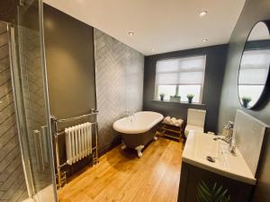a bathroom with a tub and a sink and a shower at The Etherley - Zillo in Bishop Auckland