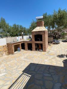a brick patio with a brick oven in a yard at Villa Maslina in Sutivan