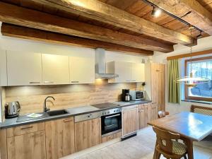a kitchen with wooden cabinets and a wooden table with a dining room at Holiday Home Solea - IST201 by Interhome in Imst