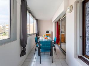 jadalnia ze stołem i niebieskimi krzesłami w obiekcie Apartment Amourêva-1 by Interhome w Cap d'Agde