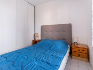 a bedroom with a blue bed and a night stand at Apartment Amourêva-1 by Interhome in Cap d'Agde