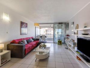a living room with a red couch and a tv at Apartment Les Goélands-1 by Interhome in Cap d'Agde