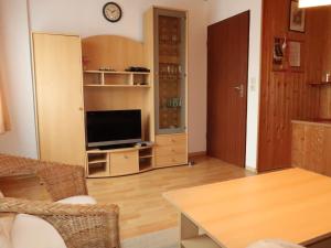 een woonkamer met een televisie en een tafel bij Apartment Hannemann-1 by Interhome in Schillig