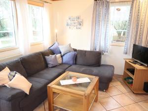 a living room with a couch and a coffee table at Chalet Friedrichsen I by Interhome in Langenhorn