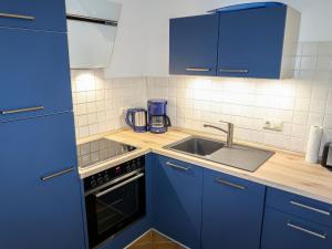 a kitchen with blue cabinets and a sink at Apartment Juliusruh-4 by Interhome in Juliusruh