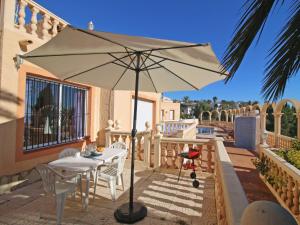 a table and chairs with an umbrella on a balcony at Apartment Canuta Baja 3 by Interhome in Calpe