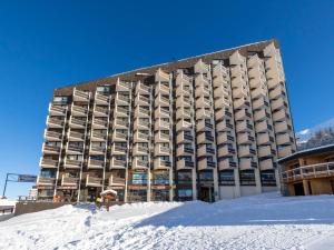 a large building with snow in front of it at Apartment Grande Masse-2 by Interhome in Les Menuires