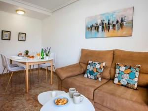 een woonkamer met een bank en een tafel bij Apartment Luz del Mediterraneo-1 by Interhome in Denia