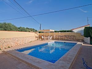 a swimming pool in a yard with a stone wall at Holiday Home Villa Servinola by Interhome in Calpe