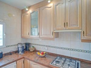 uma cozinha com armários de madeira e uma tigela de fruta no balcão em Holiday Home Villa Servinola by Interhome em Calpe