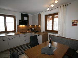 eine Küche mit einem Tisch und einer Flasche Wein darauf in der Unterkunft Apartment Neurauter - FGZ158 by Interhome in Fügen